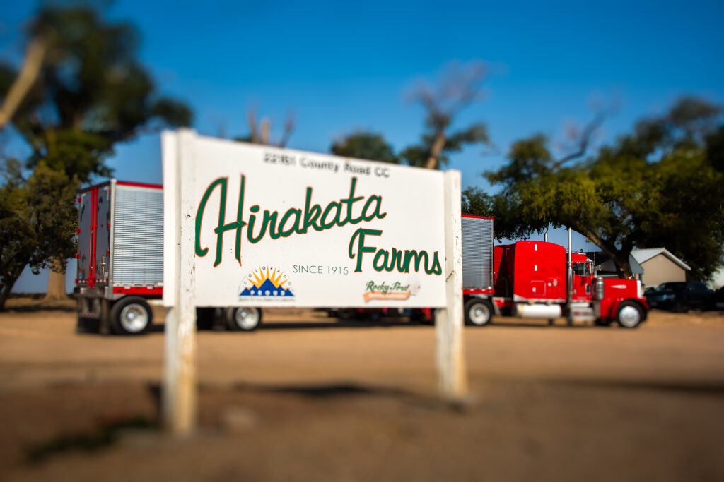 Sign that says Hirakata Farms with a semi truck in the background.