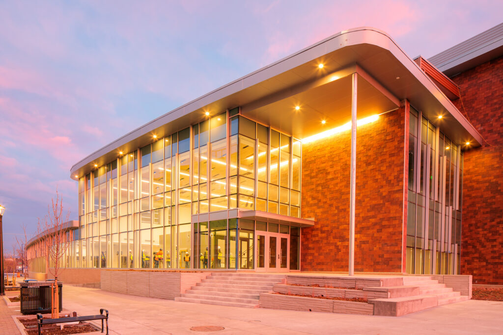 Building with lights on against a pink sky.