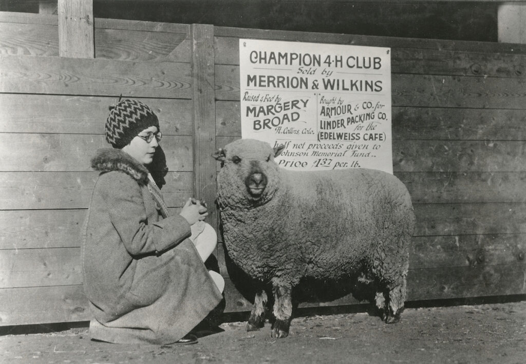 Black and white photo of a girl with a sheep.