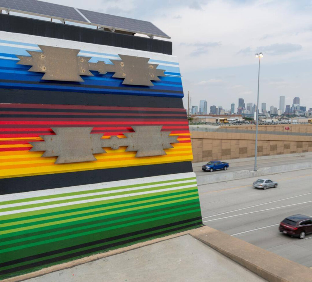 Colorful mural on the overpass of a highway.