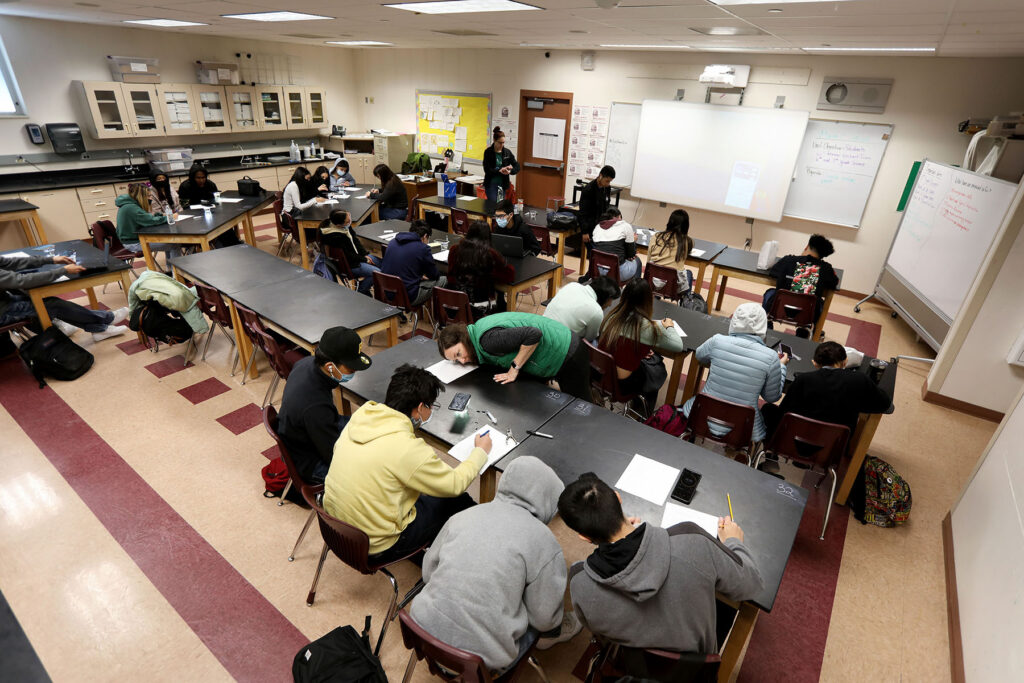 Aerial view of students at lab tables working in groups.