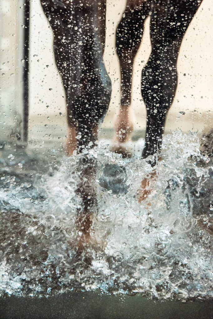 Close up of a horse's legs and hooves walking in water.