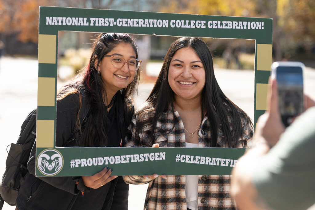 Two stands stand in a cut-out picture frame that says National First-Generation College Celebration!