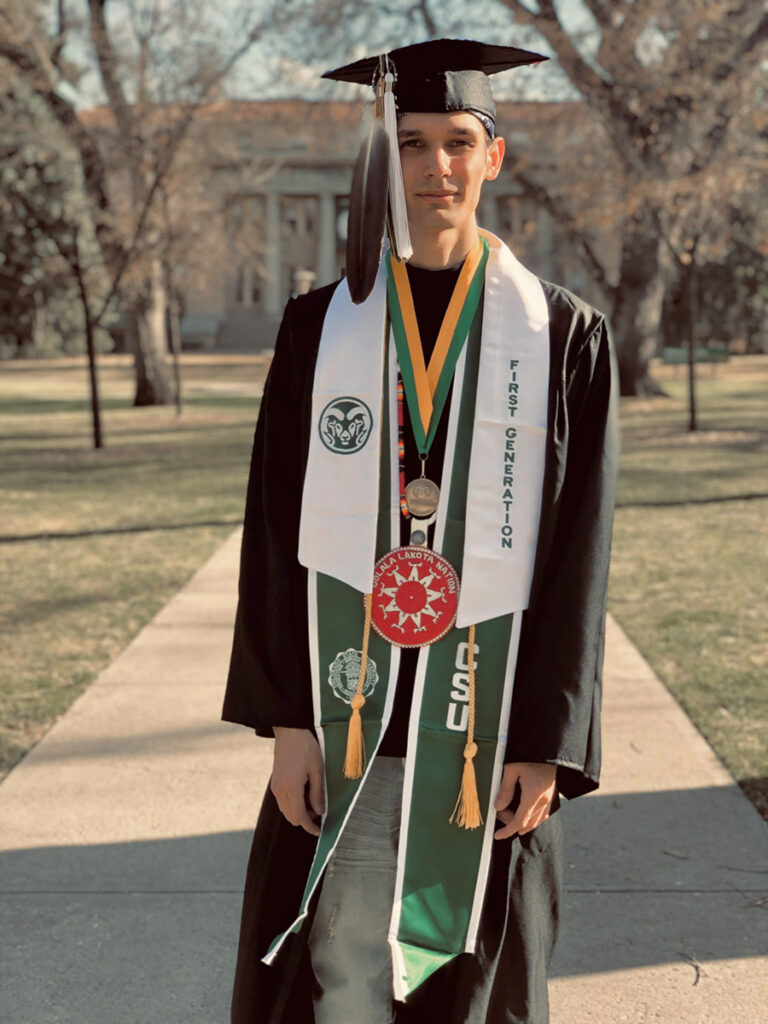 Man in CSU graduation regalia and Native American dress.