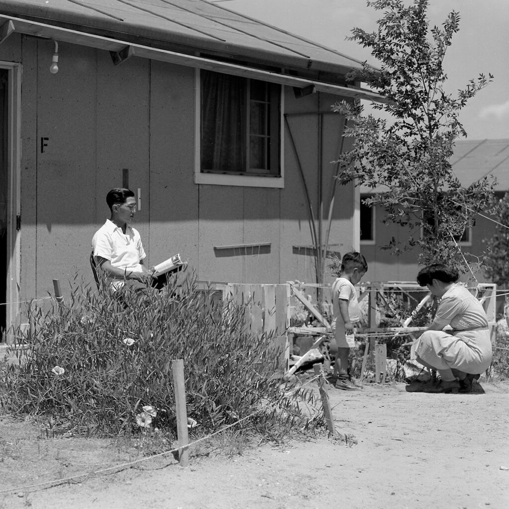 Black and white photo of a family in a front yard.