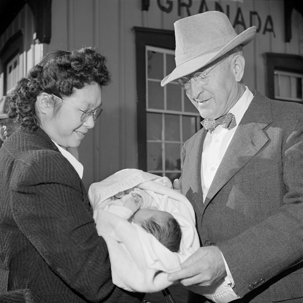 Black and white photo of two people with a baby.