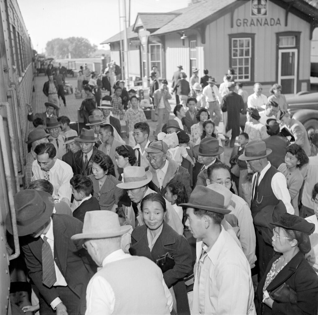 Black and white photo of a crowd on a train platform.