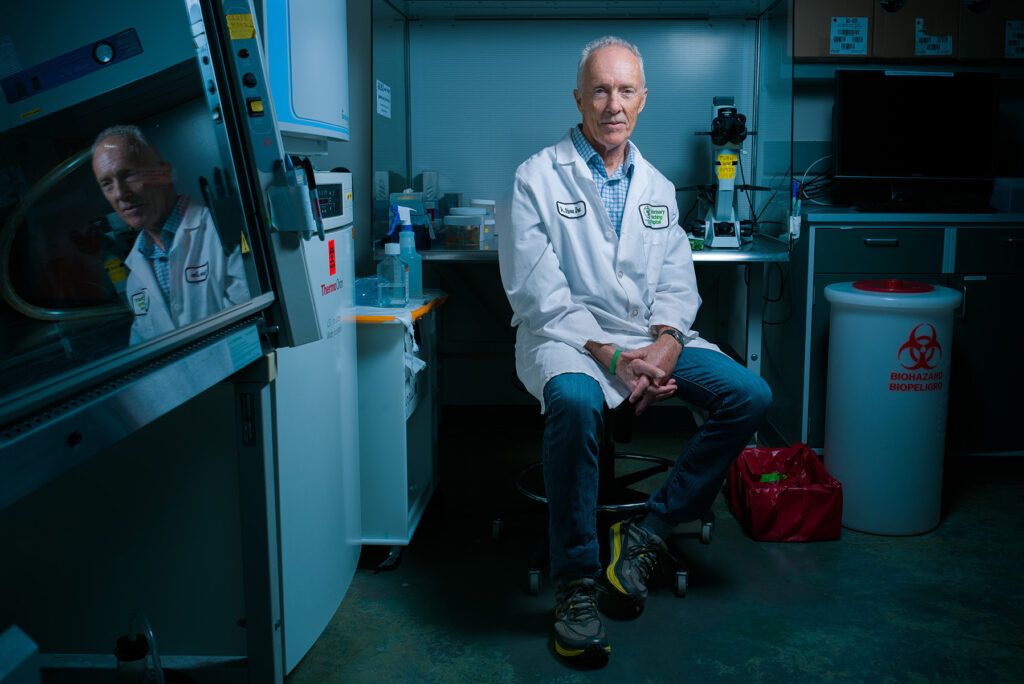 A sitting man in a lab coat.
