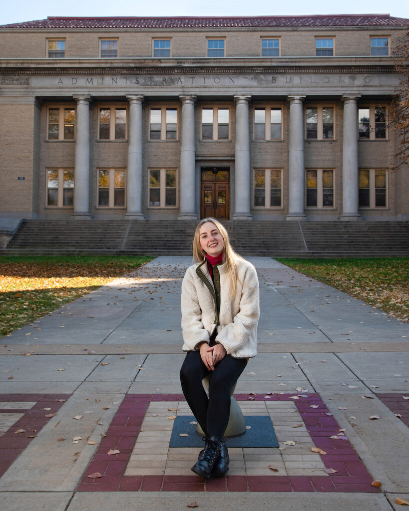 A young woman poses in front of the CSU Administration building.