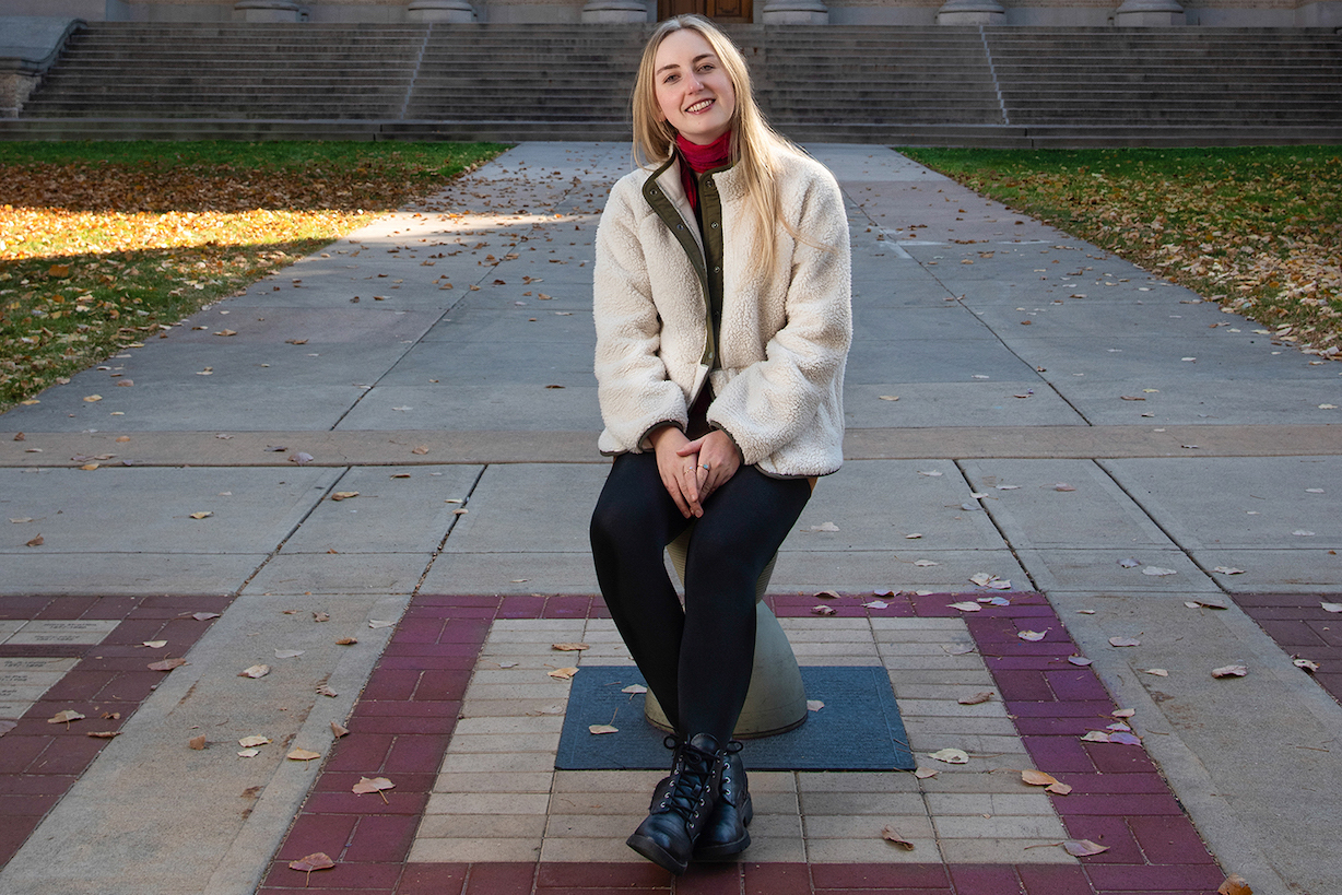 A young woman poses in front of the CSU Administration building.