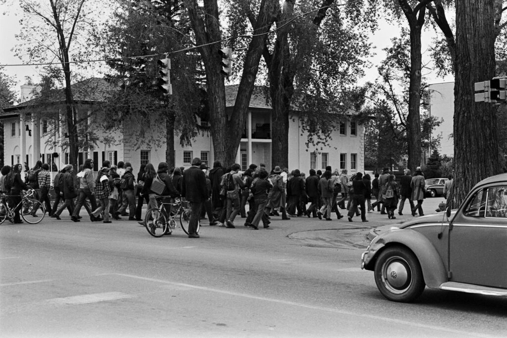 Black and white photo of a group marching down a street.