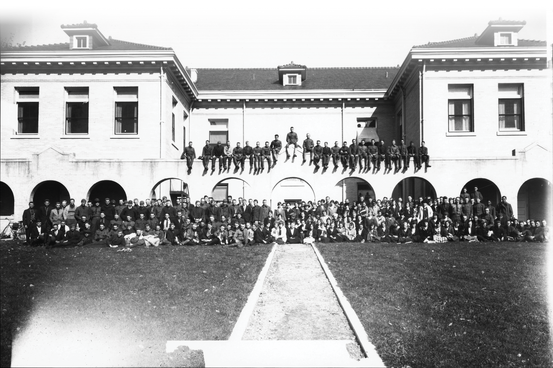Historical group photo in front of a white building.