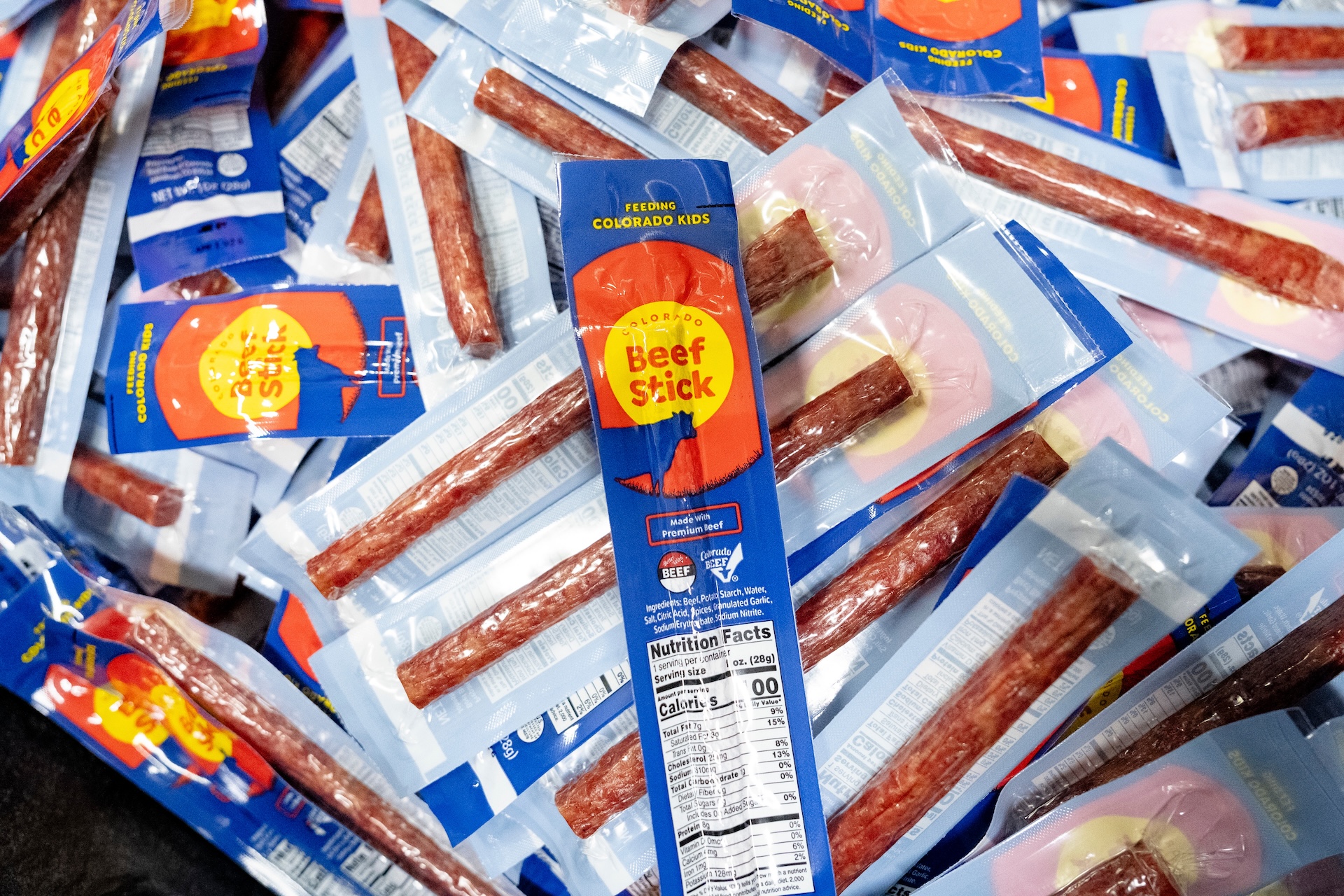 A pile of beef sticks in blue packaging.