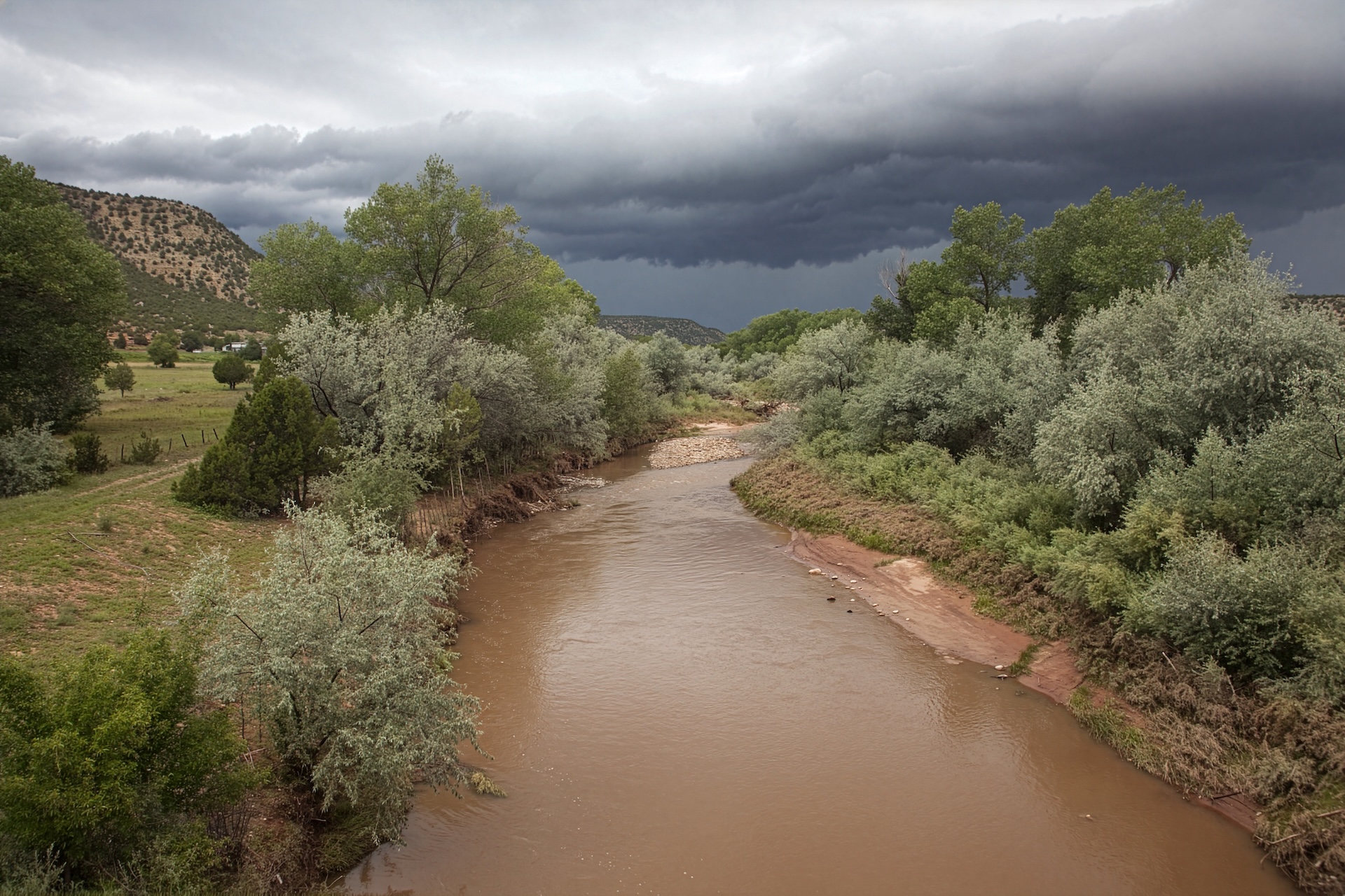 Aerial view of a wide brown river.